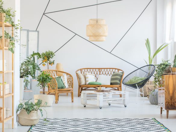 Bright living room with rattan furniture, plants, and geometric rug.