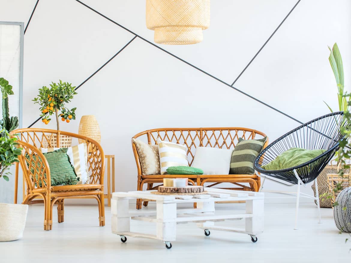 Bright living room with wicker furniture and green accents.
