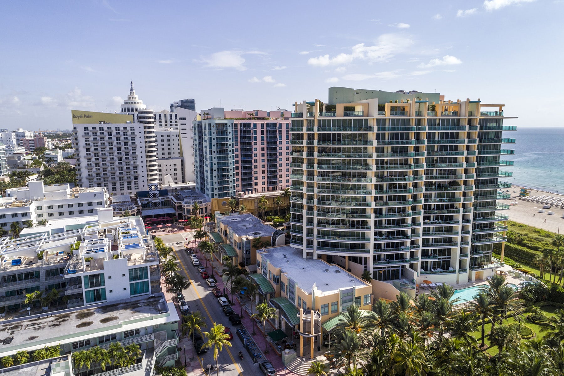 Aerial view of a coastal city with tall buildings and palm trees.