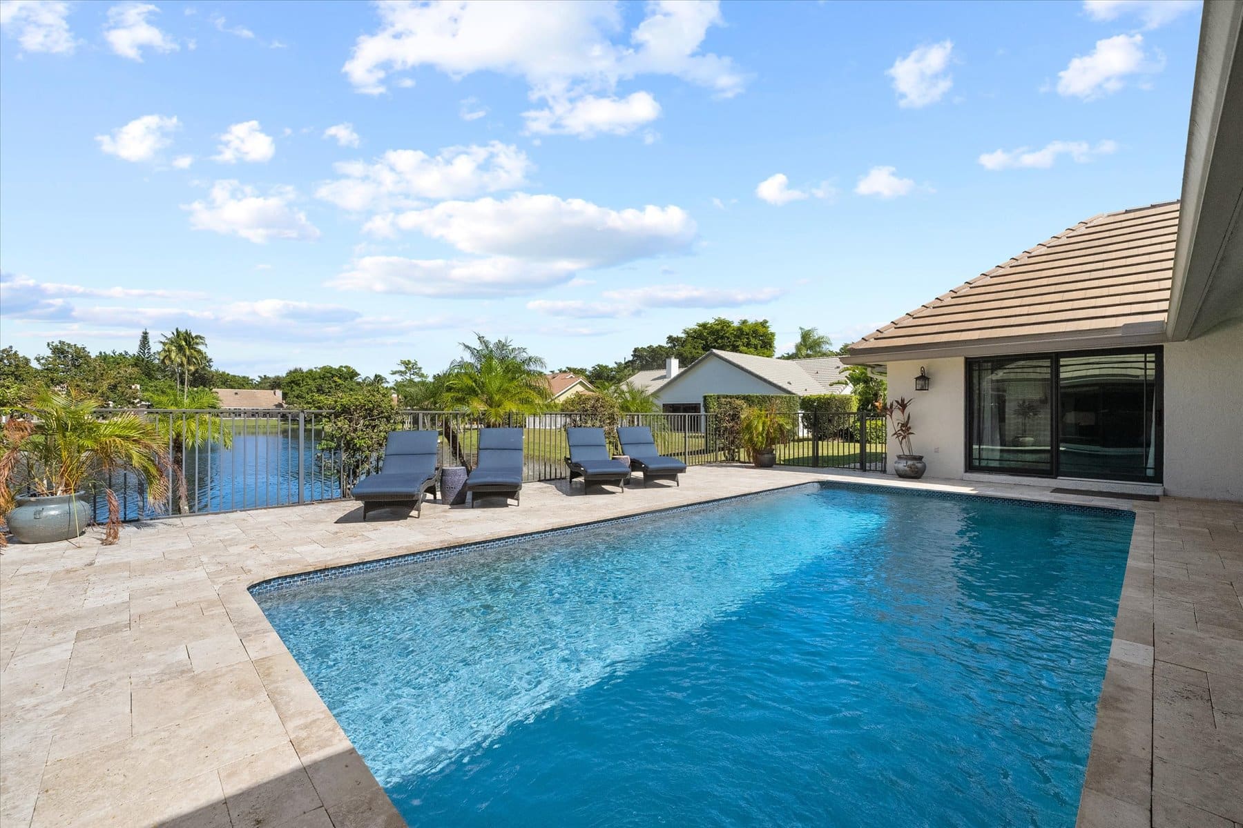Luxury poolside view overlooking a serene lake with lounge chairs.